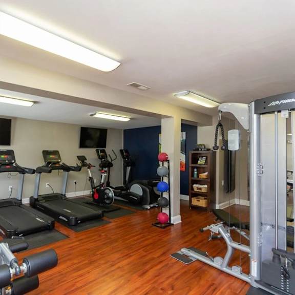 a well-equipped home gym with a variety of exercise machines at clarion crossing apartments, prg real estate management, raleigh