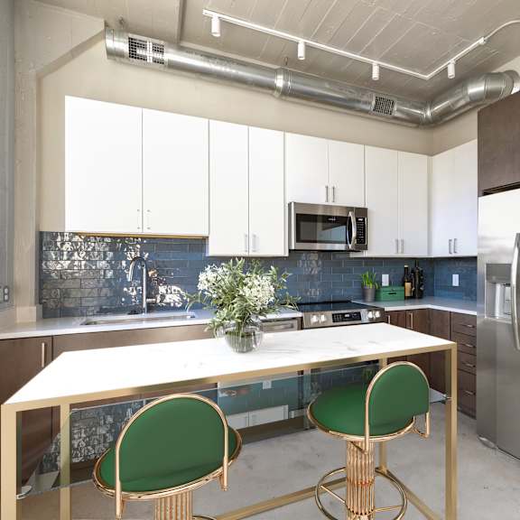 Thumbnail 5 of 7 A kitchen with a table and chairs and a refrigerator.