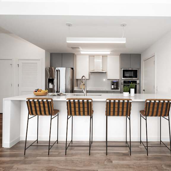 a modern kitchen with a white island and bar stools. at the locks tower, virginia