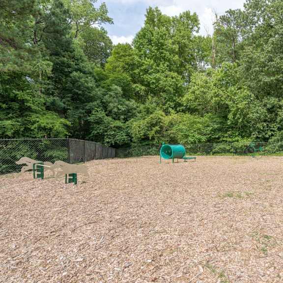 a large fenced in area with a picnic table and a red bench  at park ridge estates, durham, nc, 27713