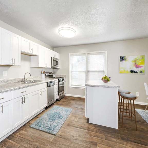 open concept kitchen with quartz countertops and island seating at hyde park townhomes, prg real estate management, chester, 23831