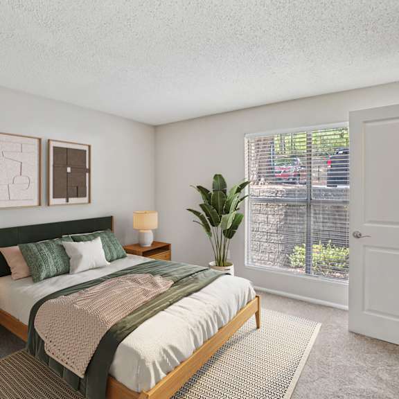a bedroom with a bed, nightstands, and a plant at beacon ridge apartments, prg real estate management, greenville, 29615