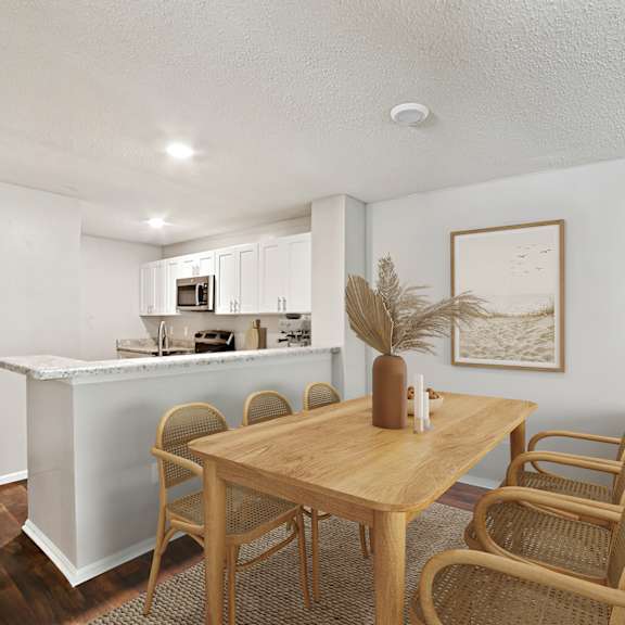 a kitchen with a table and chairs in the foreground at beacon ridge apartments, prg real estate management, greenville, 29615