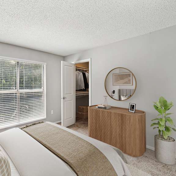 a bedroom with a bed, a dresser, and a mirror at beacon ridge apartments, prg real estate management, greenville, 29615