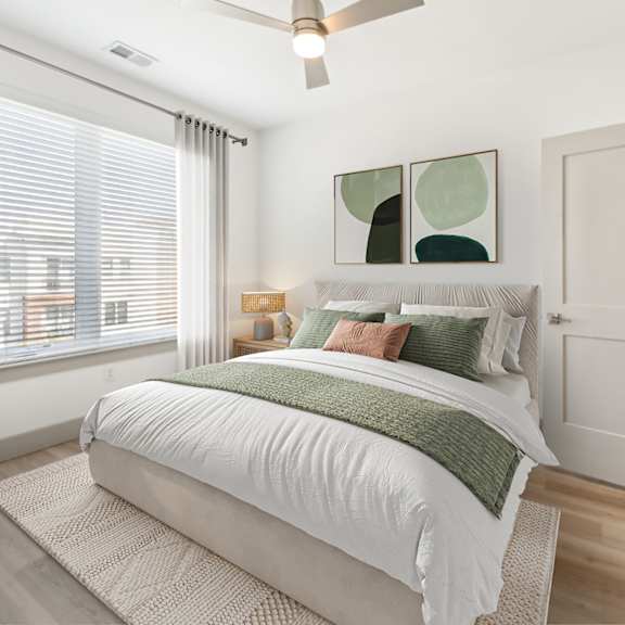 a bedroom with a large bed and a ceiling fan at the point apartments on 38th, norfolk, virginia
