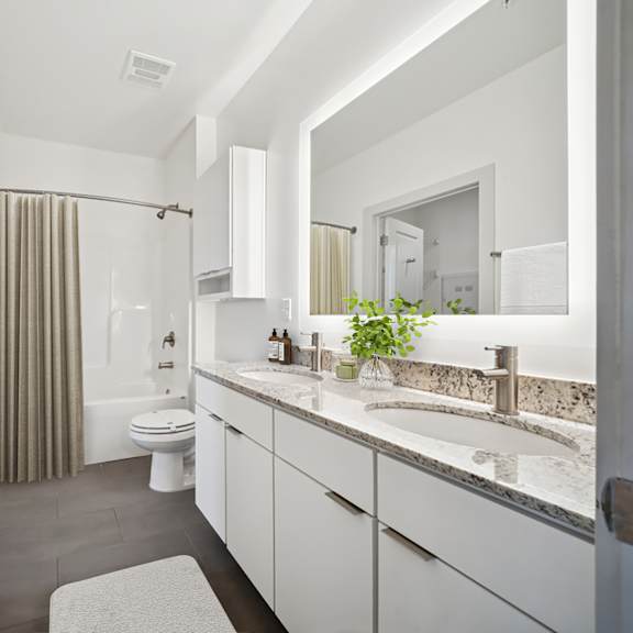 a bathroom with a toilet, sink, and mirror at circ apartments, virginia