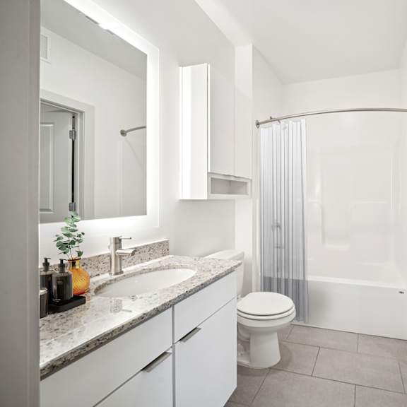 a white bathroom with a toilet, sink, and shower at circ apartments, virginia