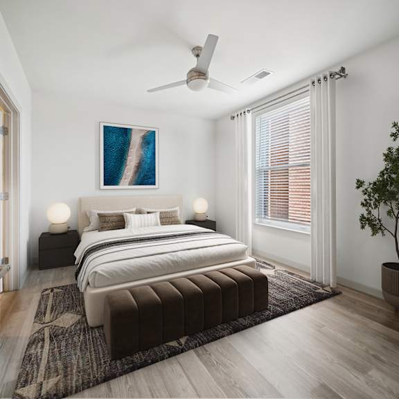 a bedroom with a large bed and a ceiling fan at circ apartments, virginia
