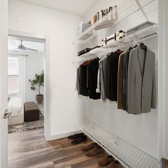 a hallway with a white door and a row of hanging coats at circ apartments, virginia