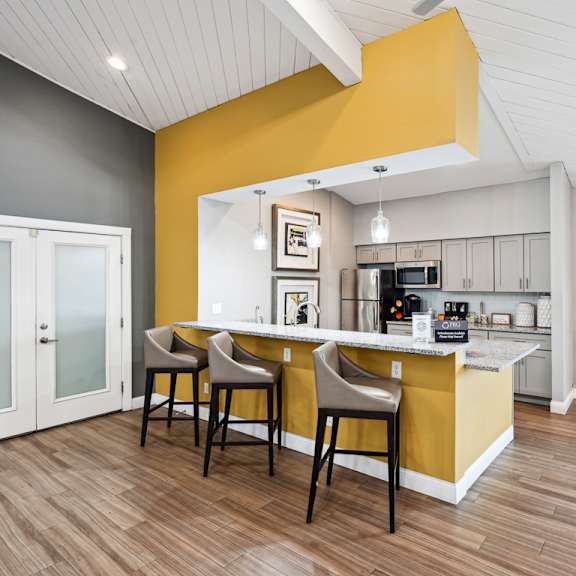 a kitchen and dining area with a yellow accent wall at the reserve at barry apartments, kansas city, missouri