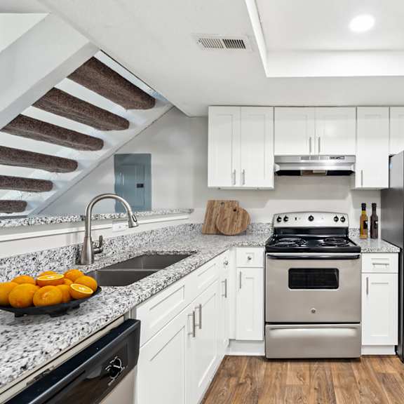 a modern kitchen with a stainless steel refrigerator and a black dishwasher at woodcreek apartments, cary, 27511
