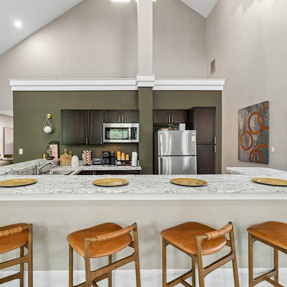a kitchen with a marble countertop and wooden bar stools.