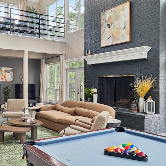 a living room with a pool table and a fireplace.