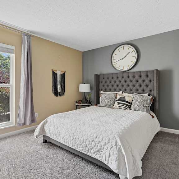 a bedroom with a large bed and a window with curtains.