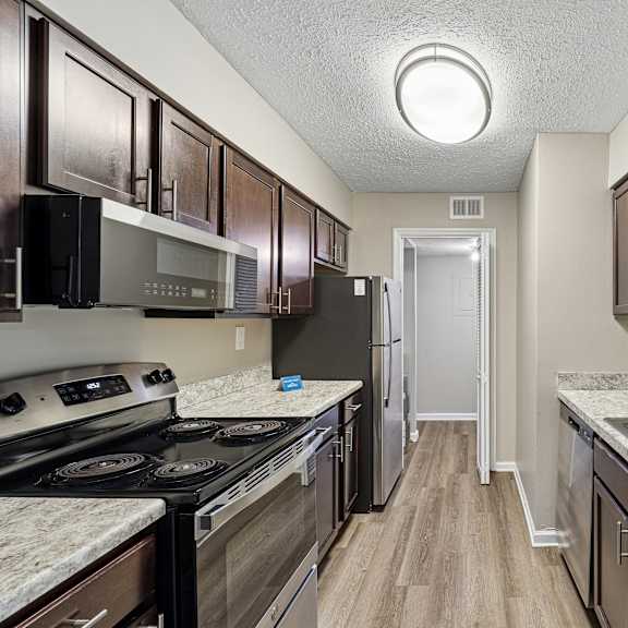 a kitchen with dark brown cabinets and a white sink.