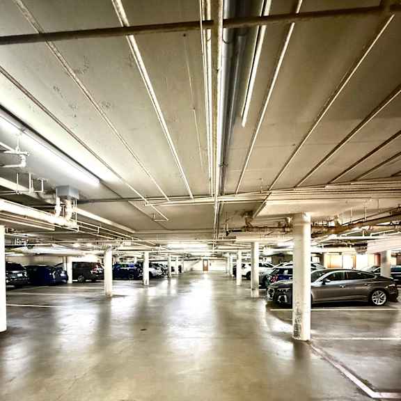 a parking garage with a concrete floor and white pillars.