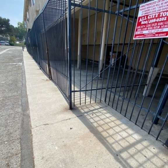 a black fence with a red and white sign attached to it.