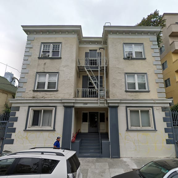 a two-story building with a car parked in front.