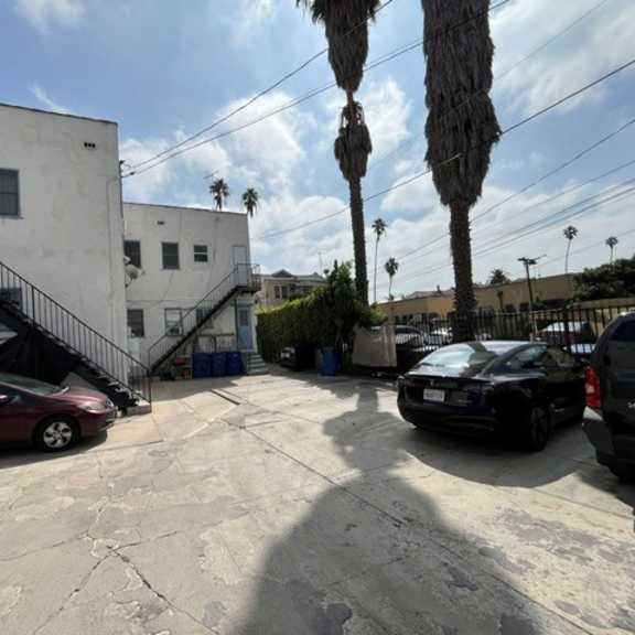 a parking lot with cars and a building with a staircase.