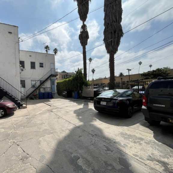 a parking lot with cars and a building with a staircase.