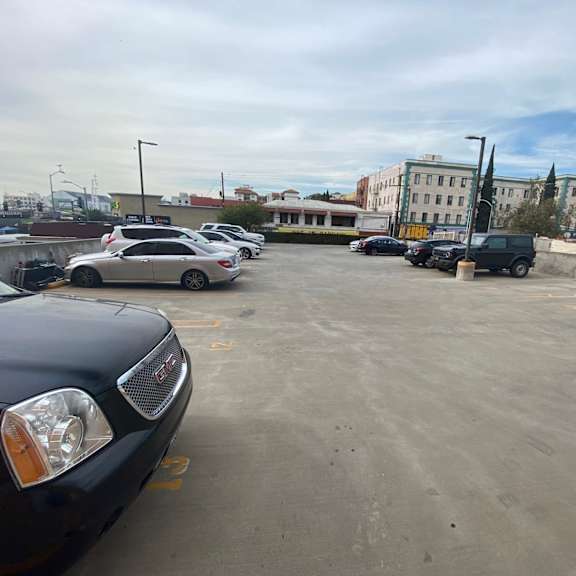 a black car is parked in a parking lot.