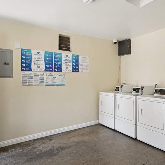 a laundry room with washers and dryers and a wall of paperwork.