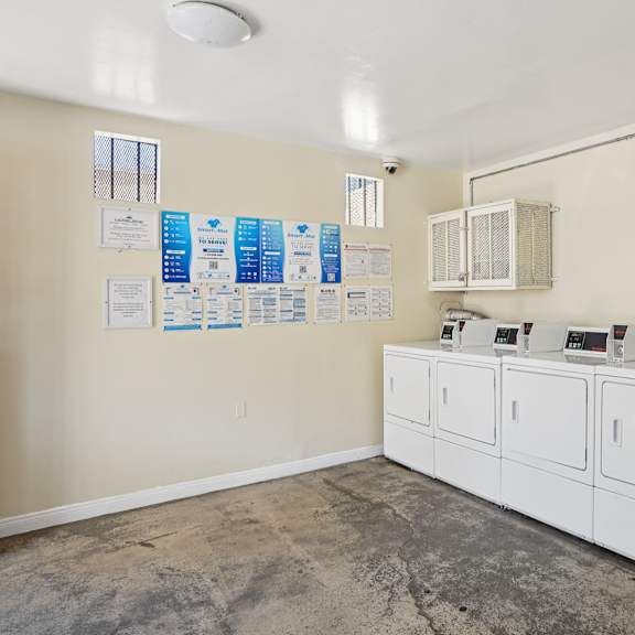a room with a white cabinet and a wall with papers on it.