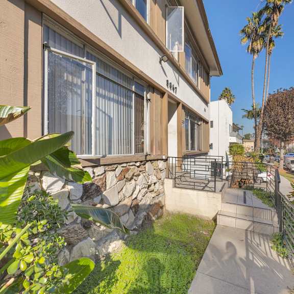 a house with a stone wall and a fence.