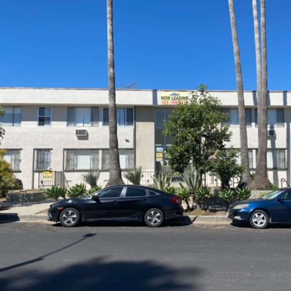 two cars parked in front of a building with a sign that says "now legging".