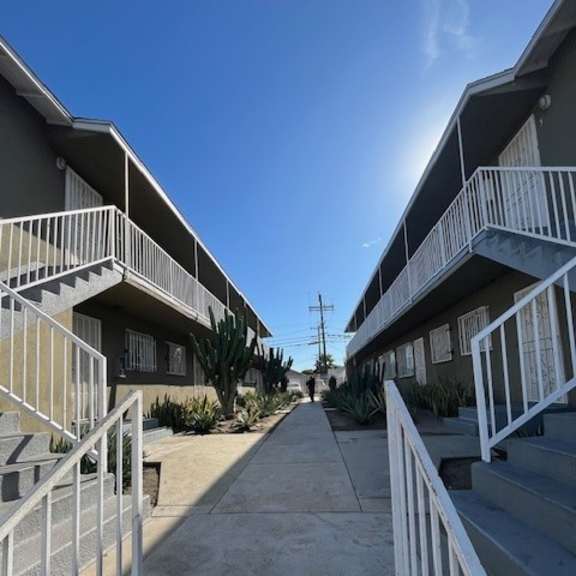 a row of apartment buildings with white railings and steps leading to the doors.