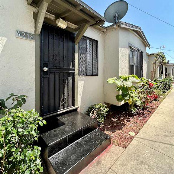 a house numbered 218 has a black door and windows.