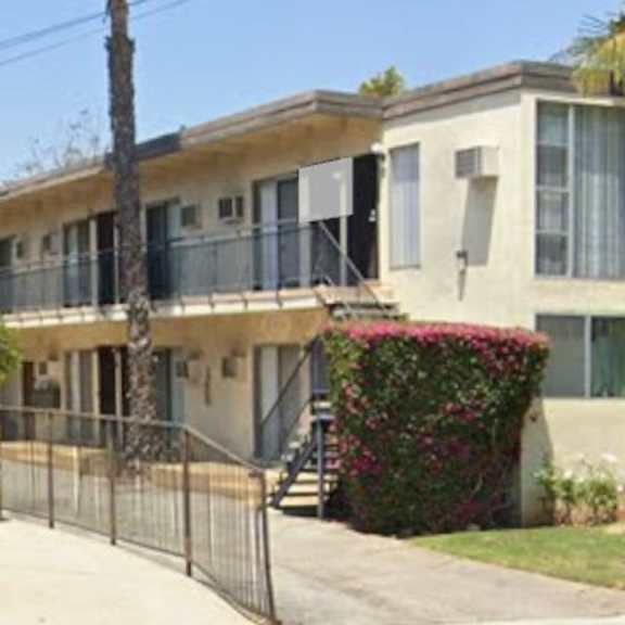 a row of houses with a fence in front.
