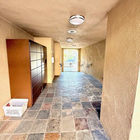 a long hallway with a tiled floor and a white box on the ground.