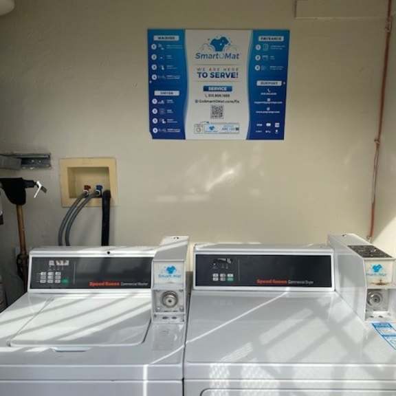 two washing machines are in front of a wall with a sign that says smart-mat.