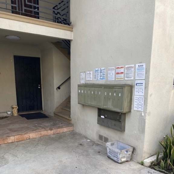 a wall with a mailbox and a bunch of papers attached to it.