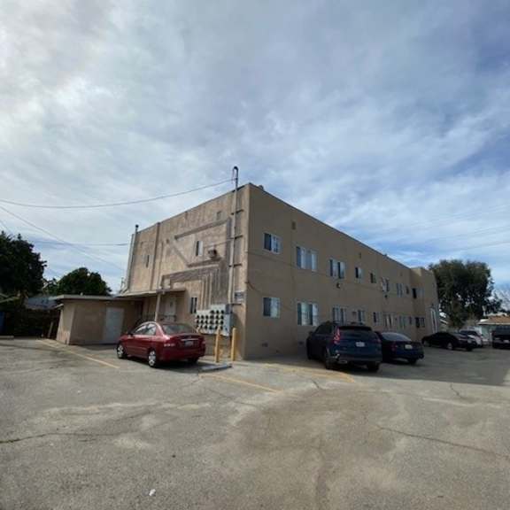 a parking lot with a building and cars.