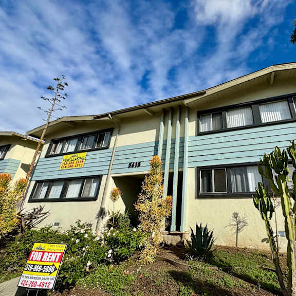 a house with a "for rent" sign in front of it.