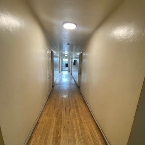 a long hallway with wooden floors and white walls.