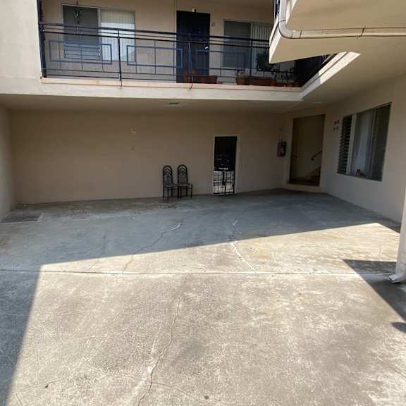 a balcony with a railing and chairs is on the second floor of a building.