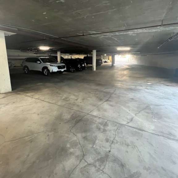 a parking garage with a white car and a black car parked in it.