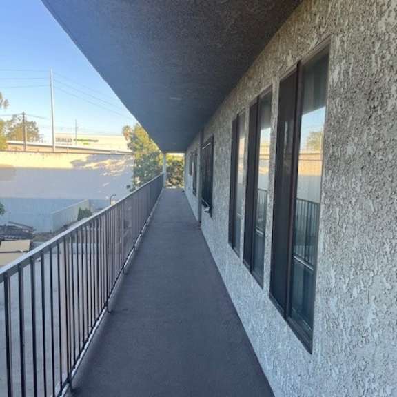 a balcony with a metal railing and a concrete wall.