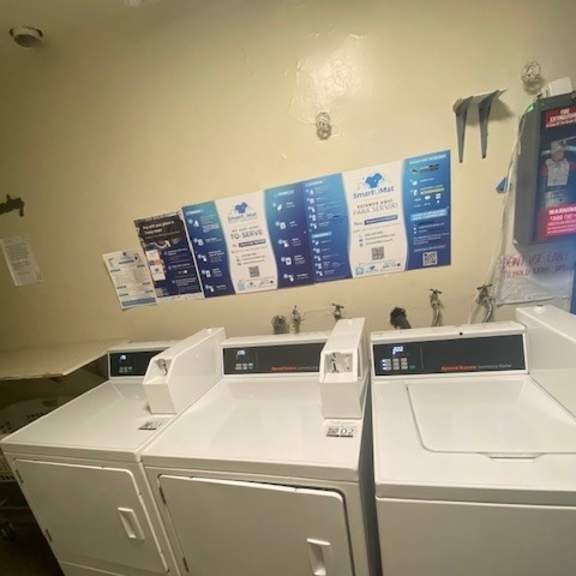 two white washing machines in front of a wall with a row of signs.