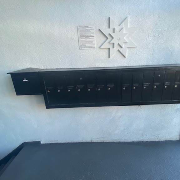 a black shelf with several compartments is mounted on a white wall.