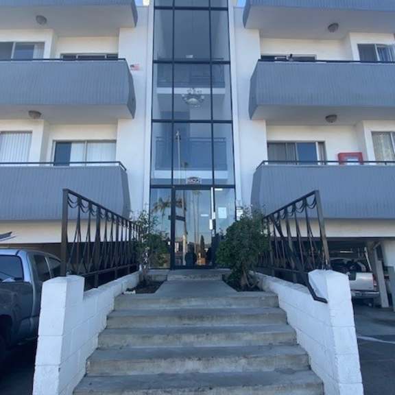 a modern building with a glass entrance and white walls.