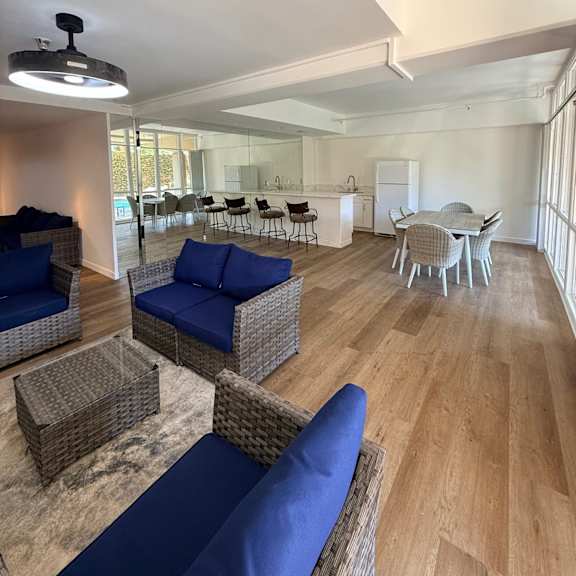 a living room with blue couches and wicker furniture.