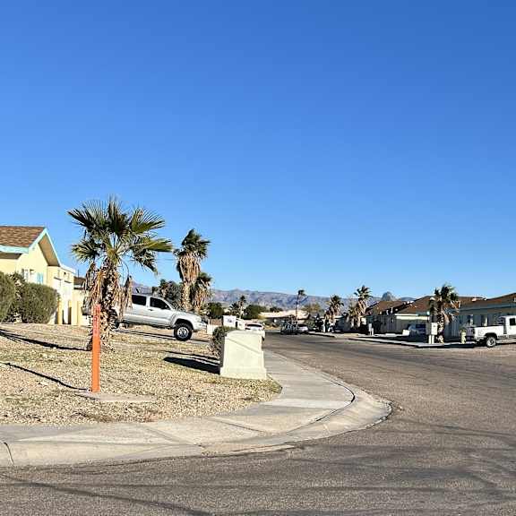 a residential street with houses and parked cars.