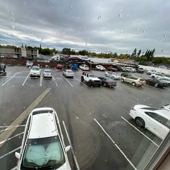 a parking lot with cars and a cloudy sky.