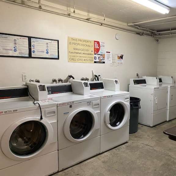 a laundromat with washers and dryers is clean and ready to use.