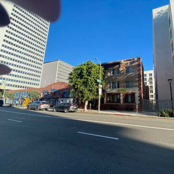 a city street with cars and buildings on either side.