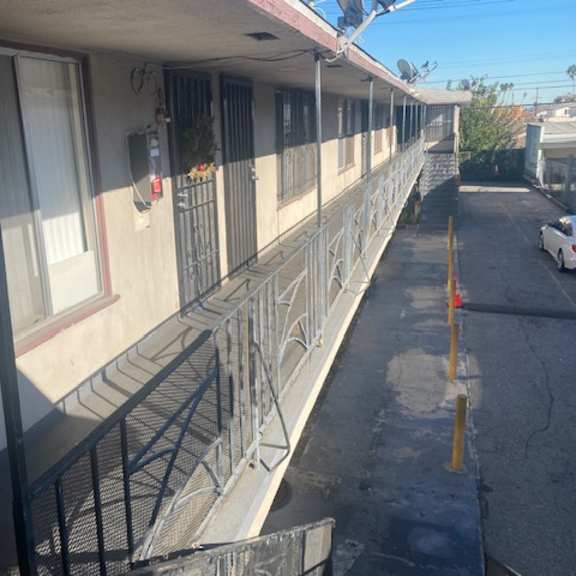 a white car is parked on the street in front of a building.
